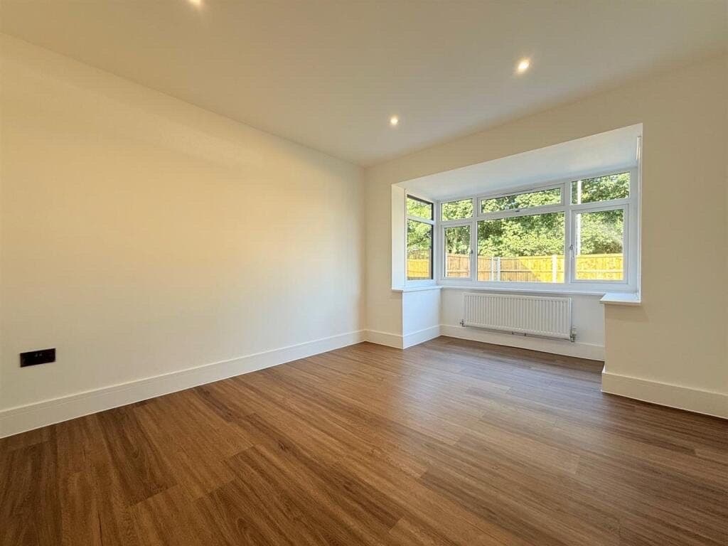 Warm oak LVT plank flooring in a freshly decorated living room with a bay window onto the garden